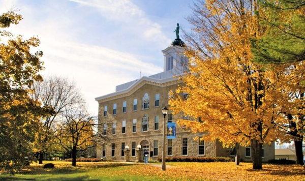 伊利诺伊大学的亚历山大-迪克曼大厅，前景的树木是秋天的颜色.